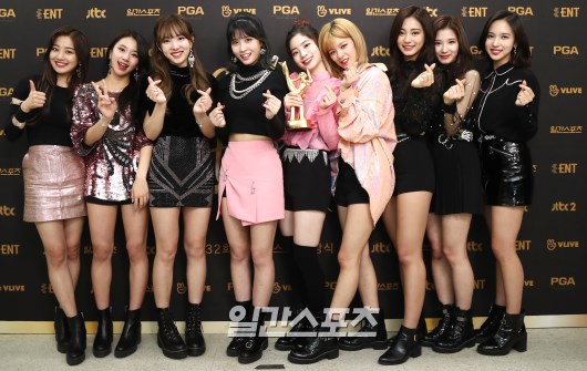 Gambar Foto Para personel Twice berfoto bersama sambil memamerkan trofi mereka usai gelaran Golden Disc Awards 2018.