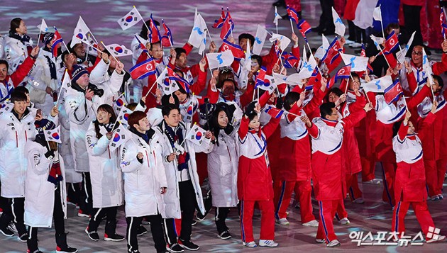 Gambar Foto Atlet Korea Selatan dan Korea Utara berdiri bersama di penutupan Olimpiade Musim Dingin Pyeongchang 2018.