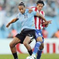 Gelandang Paraguay, Enrique Vera, berusaha merebut bola dari pemain Uruguay, Alvaro Pereira