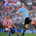 Diego Perez (kanan) menyundul bola yang dibayang-banyangi pemain Paraguay, Nestor Ortigoza
