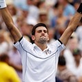 Novak Djokovic mengangkat tangannya setelah mengalahkan Roger Federer