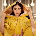 Putri Salju (Lily Collins) menyembunyikan diri dalam jubah berwarna kuning