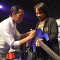 Jokowi Membubuhkan Tangan Tangan Pada Gitar Dewa Budjana