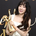 Tae Yeon tersenyum cerah sambil memegang salah satu piala Disc Bonsang miliknya dan SNSD di Golden Disc Awards 2018.