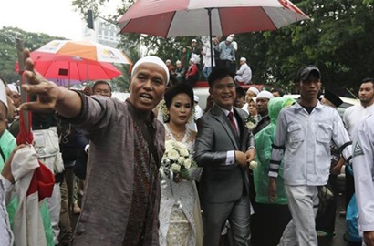 Heboh, Massa Aksi 112 Payungi Pasangan Pengantin Menuju Katedral